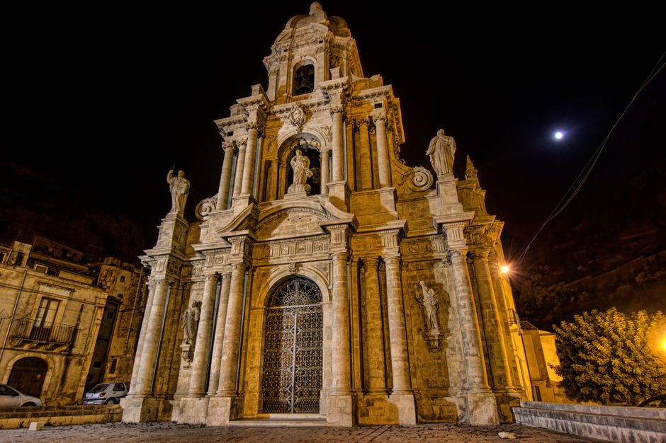 Majestic facade of St Bartholomew's Church in Scicli, Sicily, captured at night with illuminated architectural details.