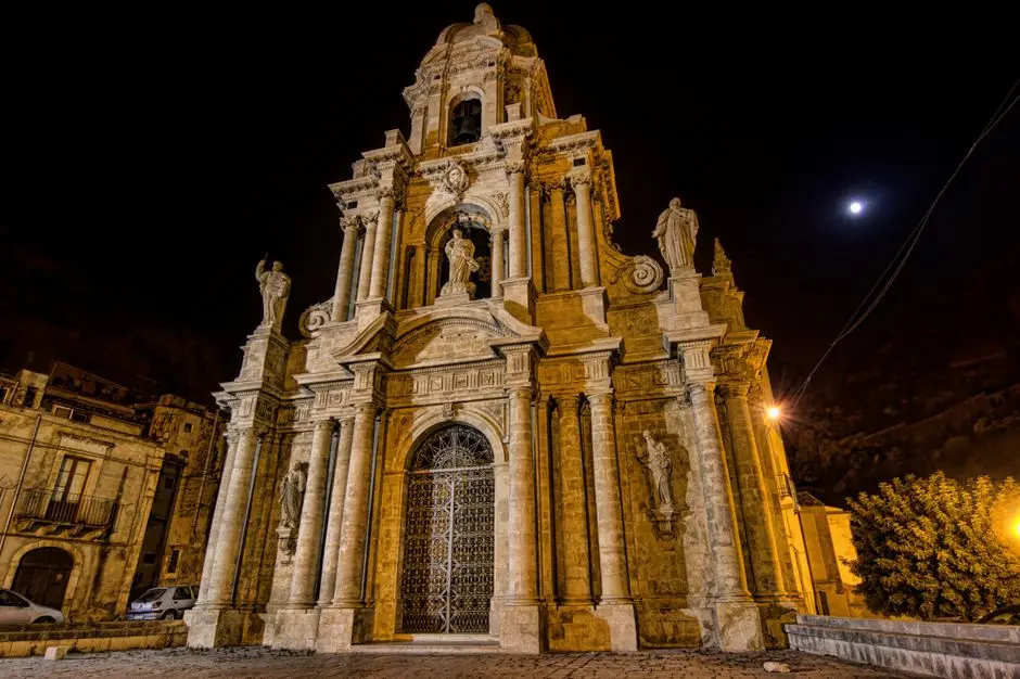 Majestic facade of St Bartholomew's Church in Scicli, Sicily, captured at night with illuminated architectural details.