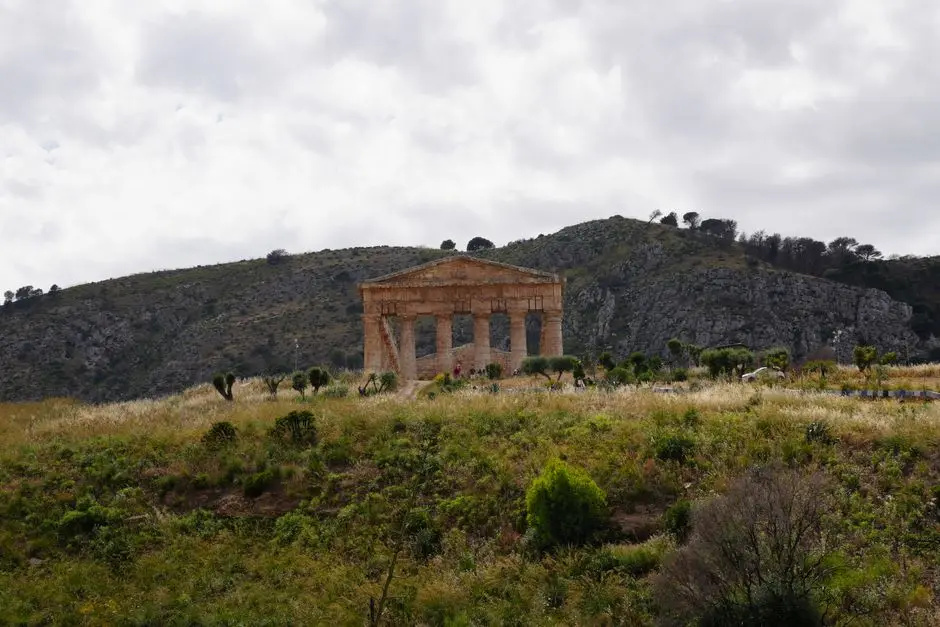 The isolated Doric temple of Segesta standing alone on a grassy hilltop, surrounded by hills, near Trapani, Sicily.