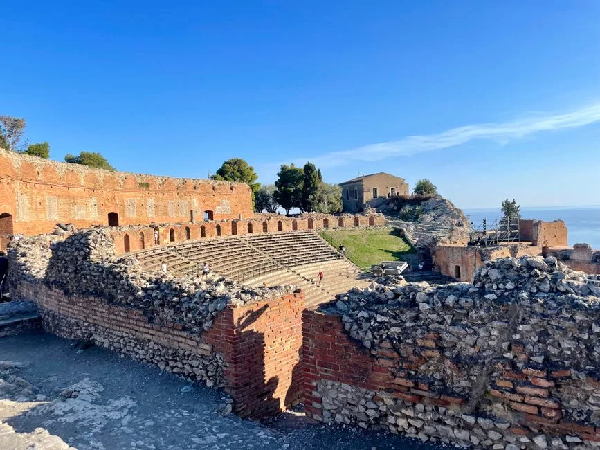 Explore the ancient Greek Theatre in Taormina, Sicily with stunning Mediterranean views.