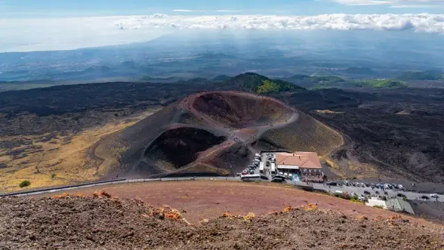 Stunning aerial view of Mount Etna's craters and landscape in Sicily, captured under a clear blue sky.