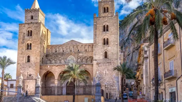 Stunning view of the historic Cefalù Cathedral in Sicily, Italy, under a bright blue sky.