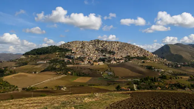 The hilltop town of Gangi in the Madonie mountains, stone houses climbing toward the Ventimiglia tower at the summit.