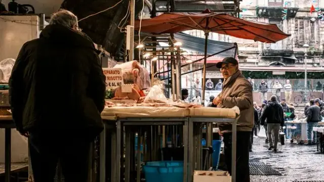 Explore the vibrant atmosphere of a bustling fish market in Catania, Sicily, showcasing local vendors and fresh produce.